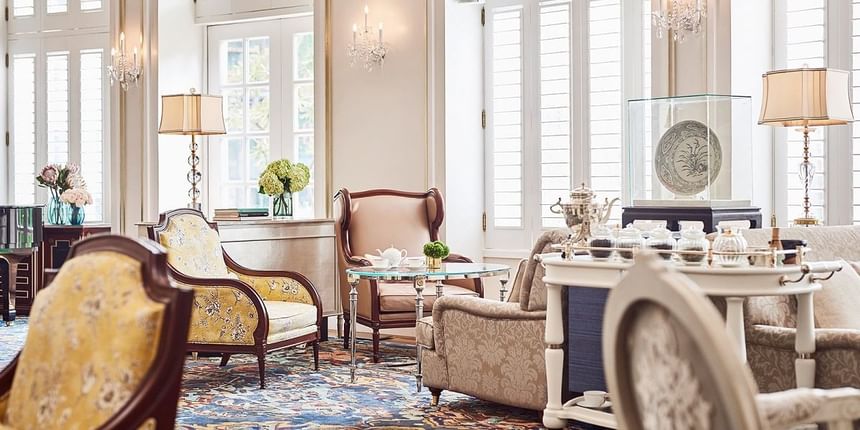 Park Lounge with plush chairs, soft lighting, and a tea set, surrounded by large windows at Park Hyatt Saigon