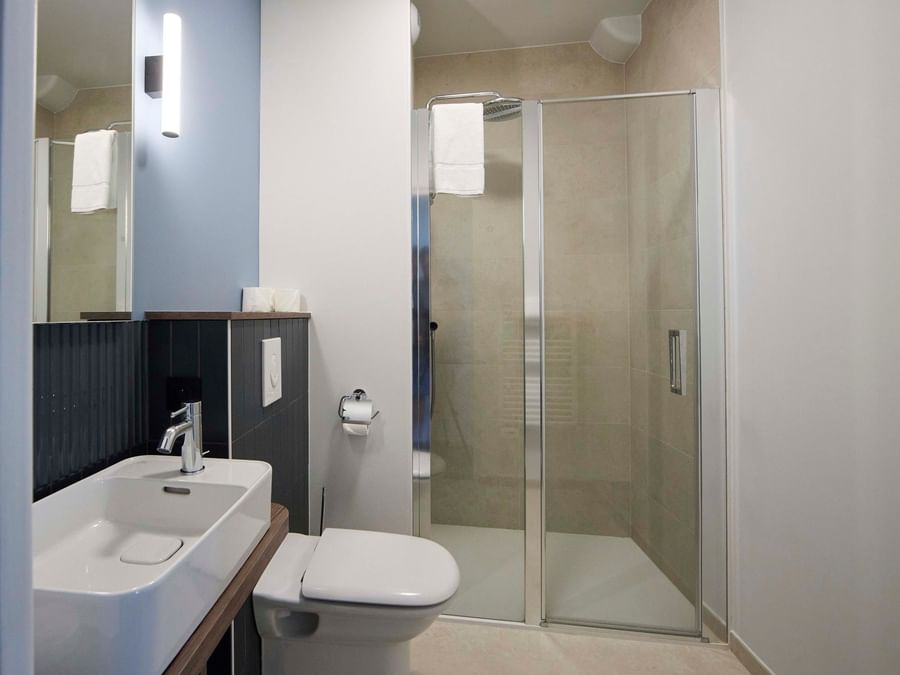 Salle de bains moderne avec douche et WC à Hôtel La Marébaudière.