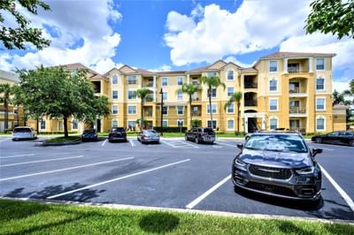 Deluxe exterior apartment complex with parking lot at Vista Cay Resort By Millenium