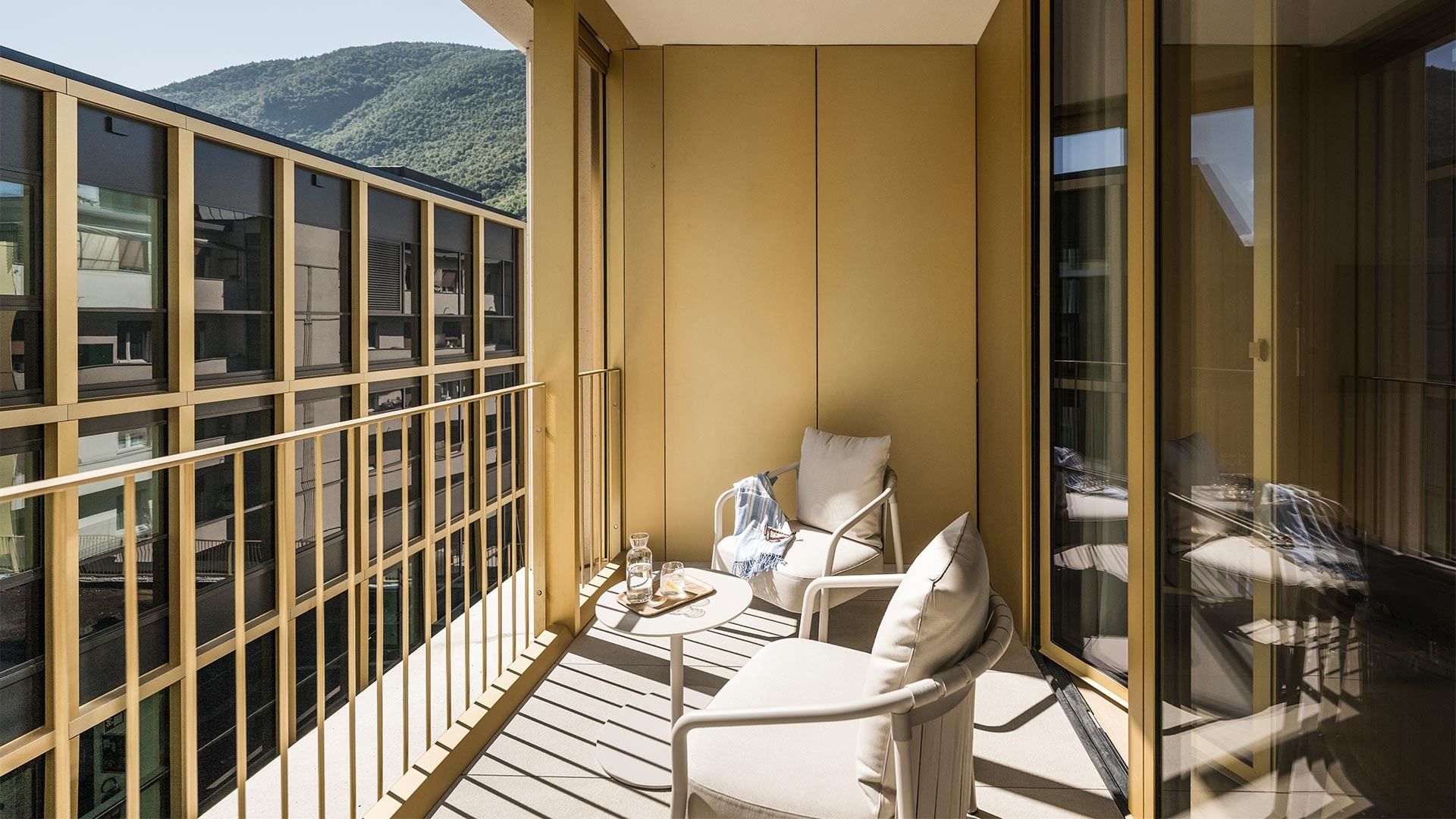 Balkon mit zwei Stühlen und Tisch im Grand Deluxe Zimmer im Falkensteiner Hotel Bozen WaltherPark.