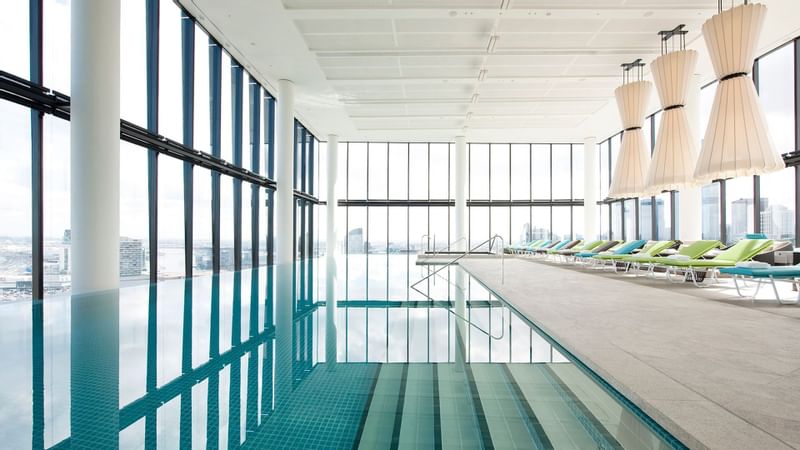 Indoor pool area with lounge chairs at Crown Metropol Melbourne