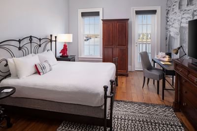 Work desk facing a bed in River View Room with Queen bed and French Balcony at River Street Inn