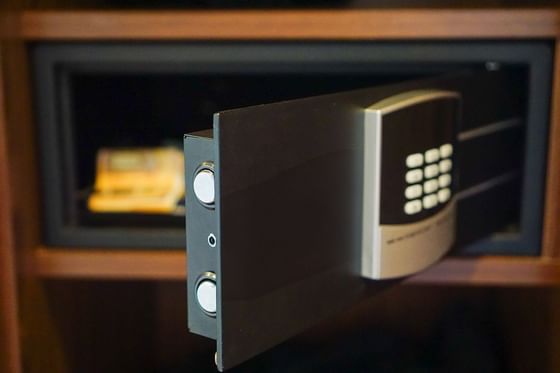 Open the digital safe by a wooden shelf under the dark interior of a closet at Paramount Hotel Seattle