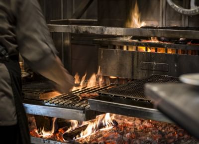 a chef moving items around on a grill