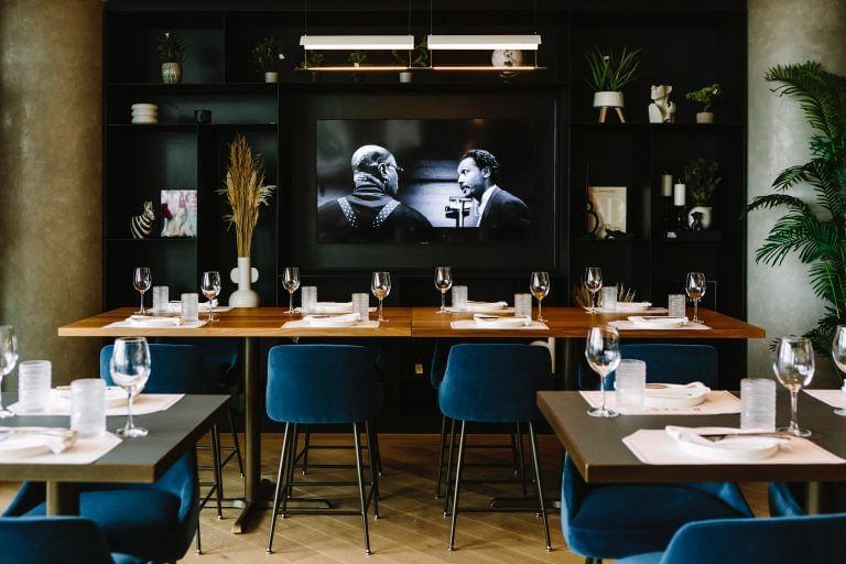Tables dressées dans le restaurant de l'hôtel X Toronto, à l'ambiance chaleureuse