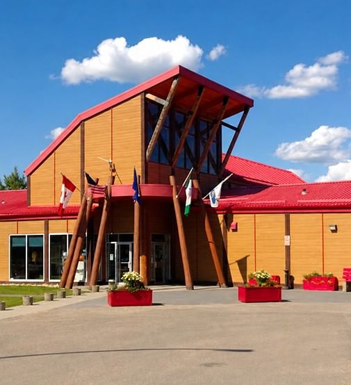 Flags and red planters outside the Forest Interpretive Centre & John & Audrey Dahl Heritage Park near Coast Whitecourt Hotel