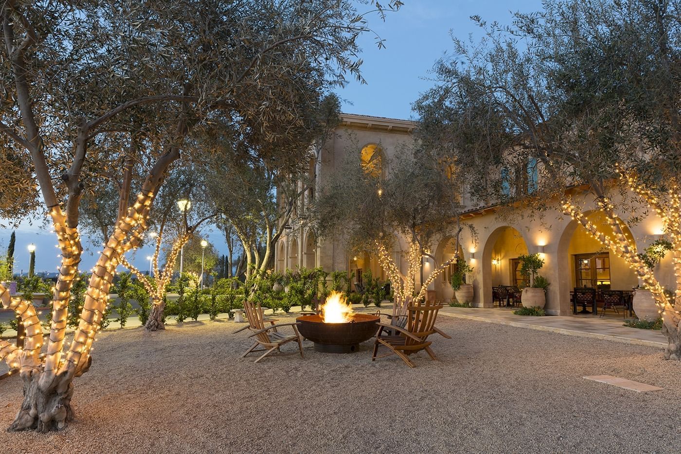 Fire pit with wood lounge chairs surrounding it.