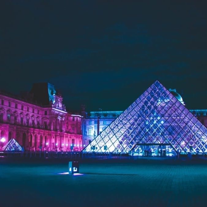 Louvre museum with lights at night near The Originals Hotels