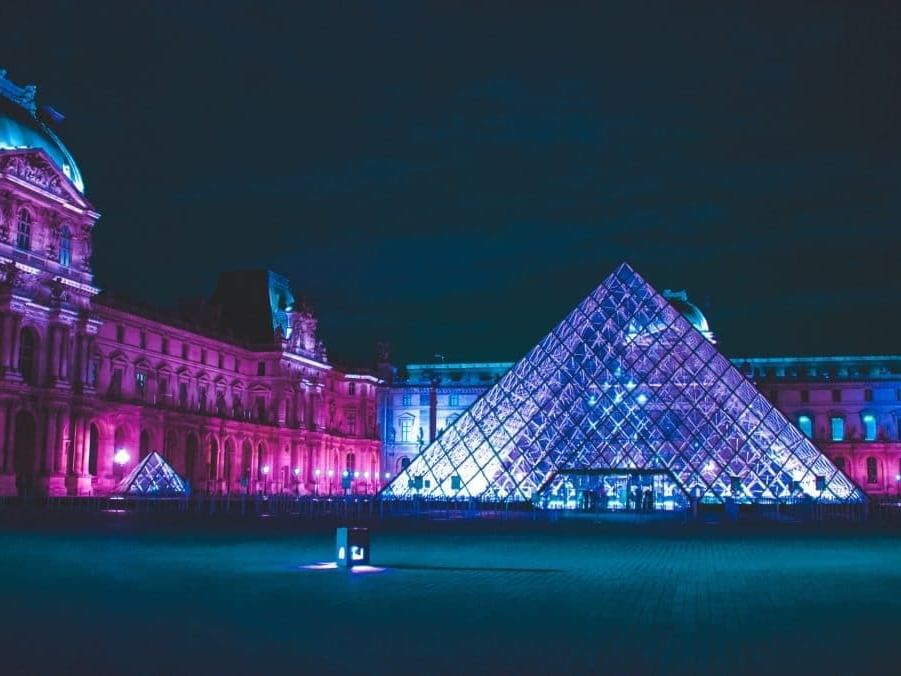 Louvre museum with lights at night near The Originals Hotels