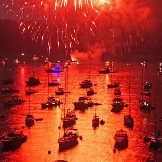 Boats on water with fireworks illuminating the night sky at Catalina Island Company