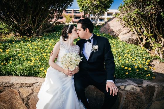 Newly wedded couple kissing for a photo at Hotel Coral y Marina