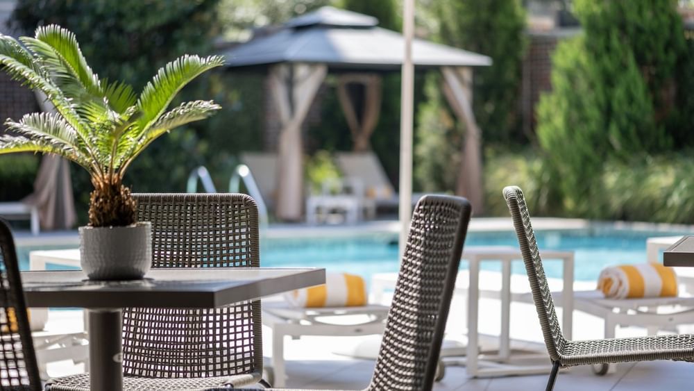 Patio table and chairs with pool view at Warwick Melrose - Dallas.