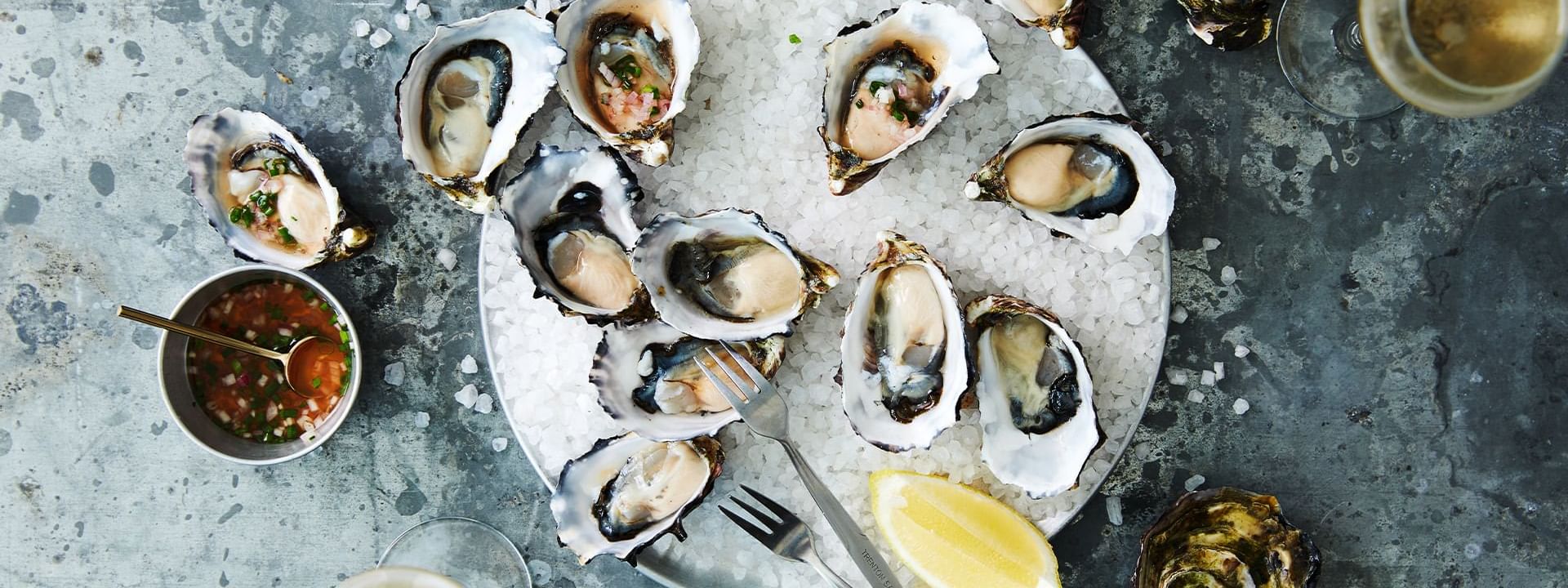Freshly shucked oysters on ice with sauce, an elegant appetizer at Steak & Oyster Co. by Sean Connolly in Novotel Sydney