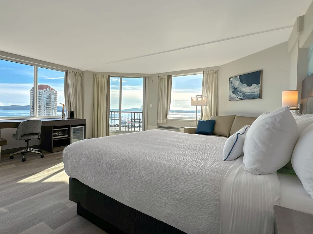 Hotel guestroom with king bed, work desk and a chair