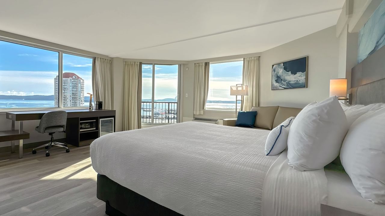 Hotel guestroom with king bed, work desk and a chair