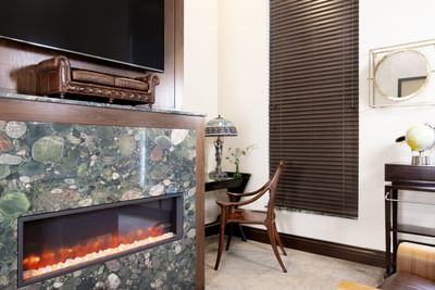 Marble fireplace, TV & work desk in King Premiere Library at Retro Suites Hotel