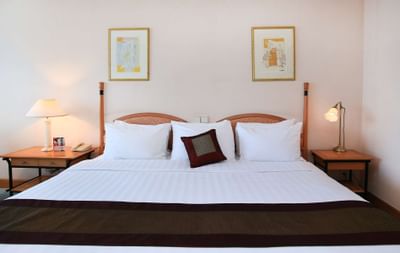 Neatly made king bed in Grand Deluxe Room at Hanoi Daewoo Hotel
