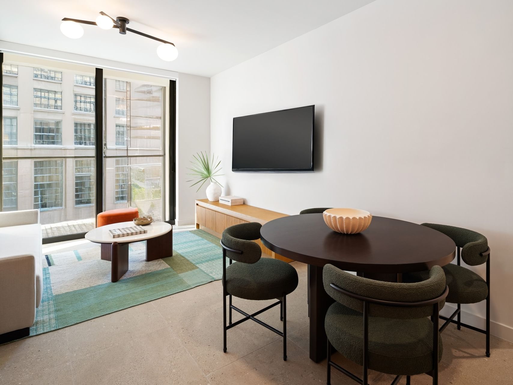 TV lounge with dining table near window in Accessible One Bedroom King Suite at The Crosby Miami World Center