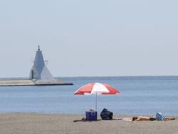 Person relaxing & sun bathing on Erieau Erie Beach near Retro Suites Hotel