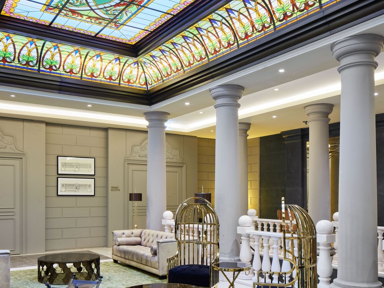 Eleganter Loungebereich mit stilvollen Sitzmöbeln und Säulen im Titanic Gendarmenmarkt Berlin.