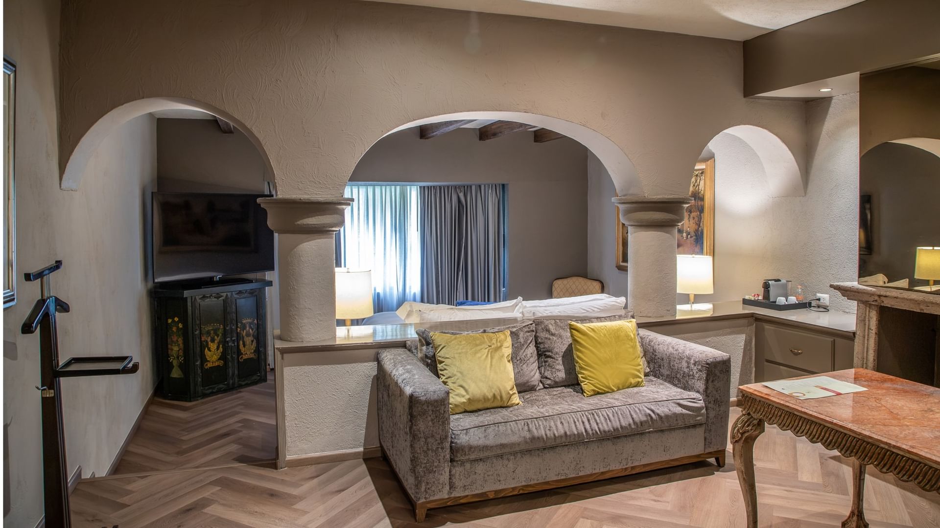 Master Suite King con arcos de piedra, sala de estar y cama king en Quinta Real Guadalajara