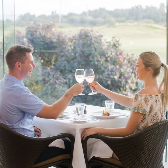 Couple cheering glass of wine in Barretts Restaurant at Pullman Magenta Shores