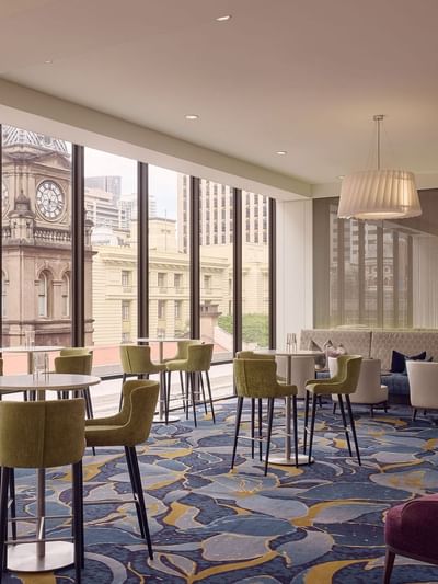 Modern interior with elegant dining settings overlooking a cityscape in Cuvée at Sofitel Brisbane Central