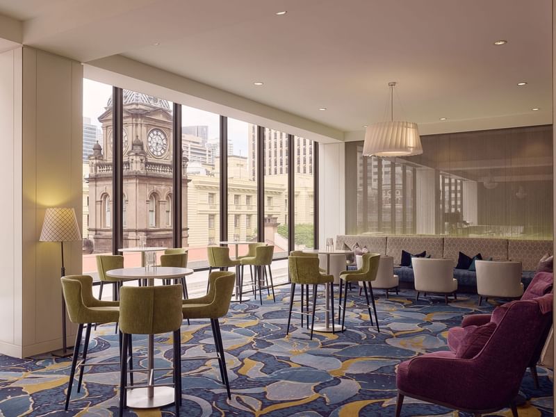 Modern interior with elegant dining settings overlooking a cityscape in Cuvée at Sofitel Brisbane Central