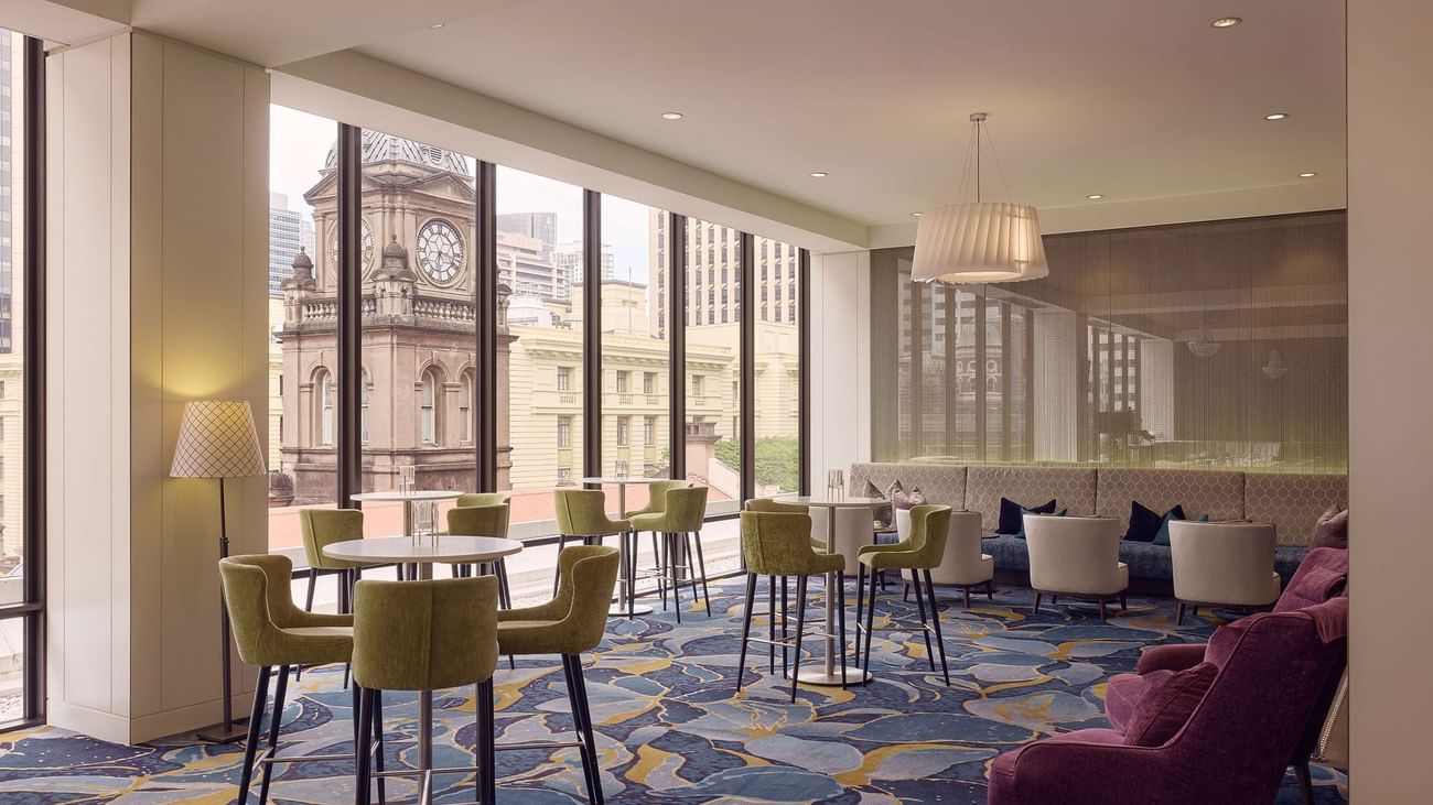 Modern interior with elegant dining settings overlooking a cityscape in Cuvée at Sofitel Brisbane Central