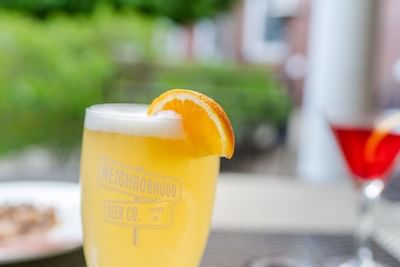 Close-up of a beverage from Neighborhood Beer Co., garnished with a slice of orange, at a restaurant at The Exeter Inn