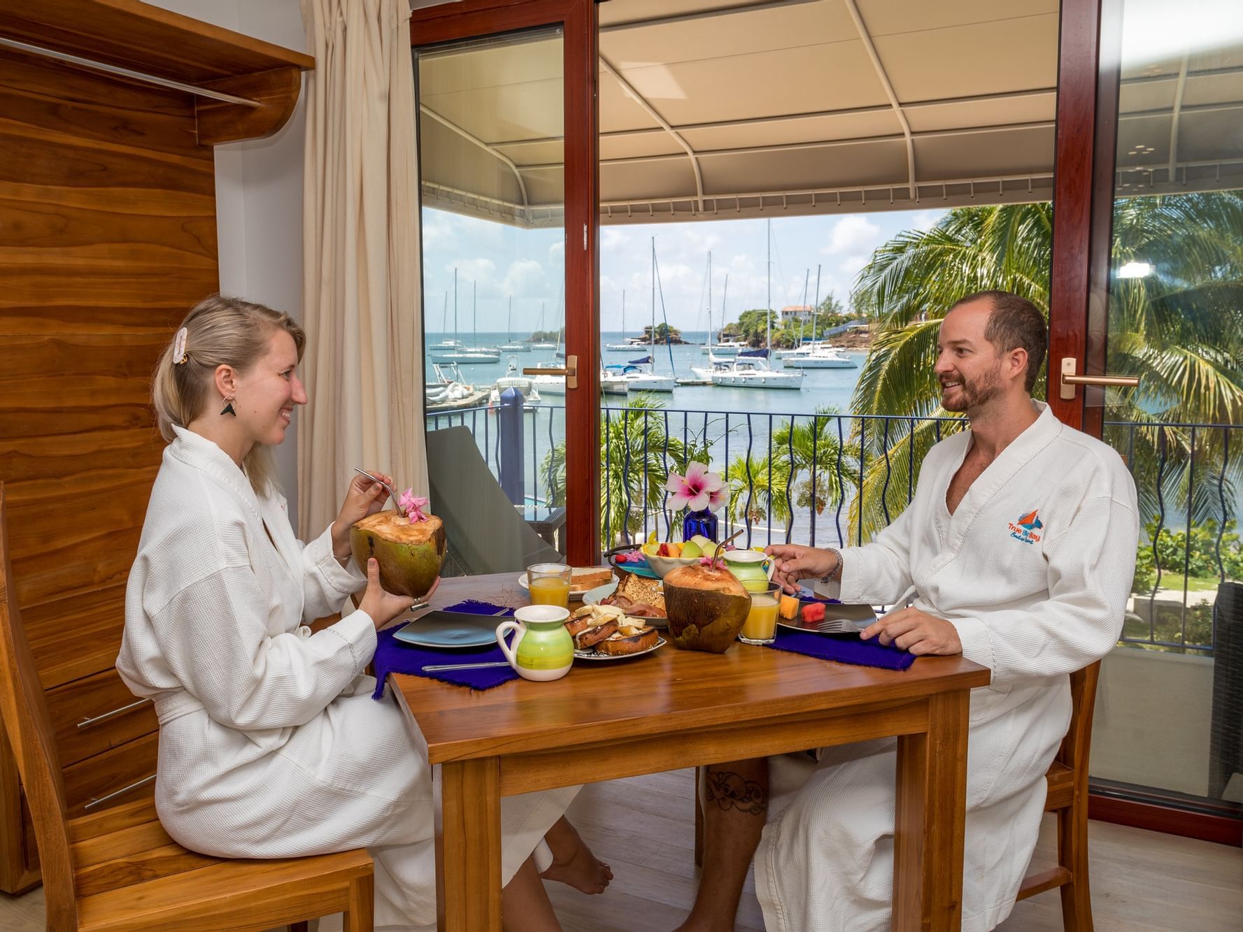 A couple enjoying a meal in a hotel room at True Blue Bay Hotel