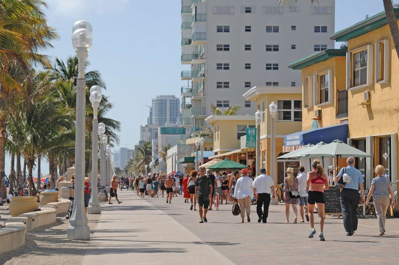 Lively boardwalk at Hollywood Beach near The Diplomat Resort, with people strolling and shops