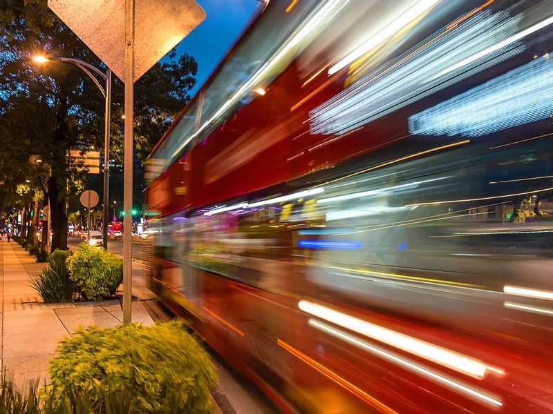 A bus at speed by a station near Gamma Hotels