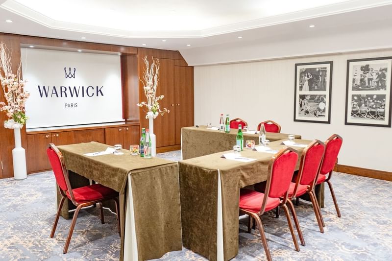Event room with tables arranged in U-shape and project screen at Warwick Paris Champs Elysées