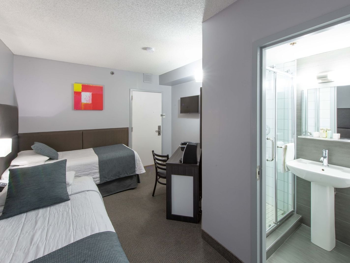 2 Single beds, TV lounge area and bathroom in Twin Room at Travelodge Montreal Centre