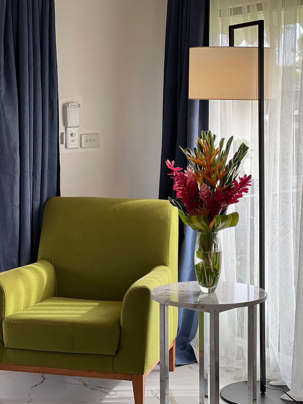 Green chair, floral vase, and lamp in Garden Bungalow at Warwick Le Lagon - Vanuatu, Efate.