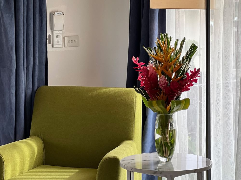 Green chair, floral vase, and lamp in Garden Bungalow at Warwick Le Lagon - Vanuatu, Efate.