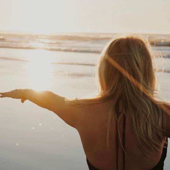 BESOUL Yoga at ICONA Diamond Beach Thurs and Sun at 8 am Blonde women with sun shining on beach