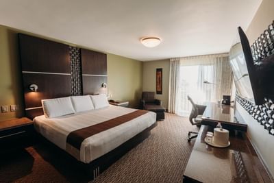 Large bed, chair & TV in Standard Room at Araiza Mexicali