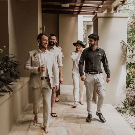 Groom posing with friends at Pullman Palm Cove Sea Resort