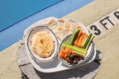 A plate of food served next to the pool at The Savoy Hotel & Beach Club