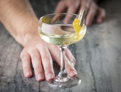 bartender pushing a cocktail towards a guest
