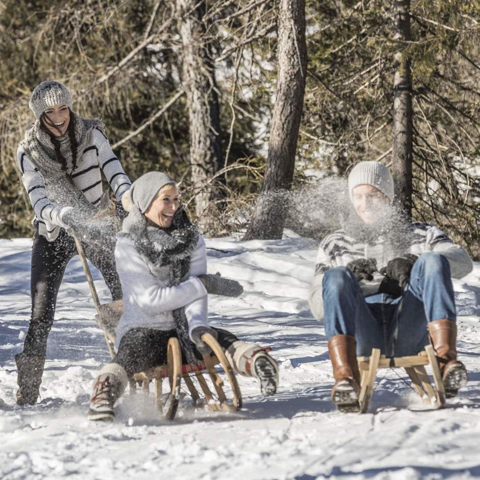 A group enjoying tobogganing near Falkensteiner Hotels