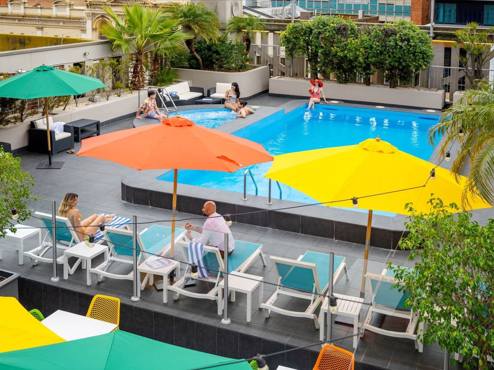 People lounging by the outdoor swimming pool at Grand Chancellor Adelaide