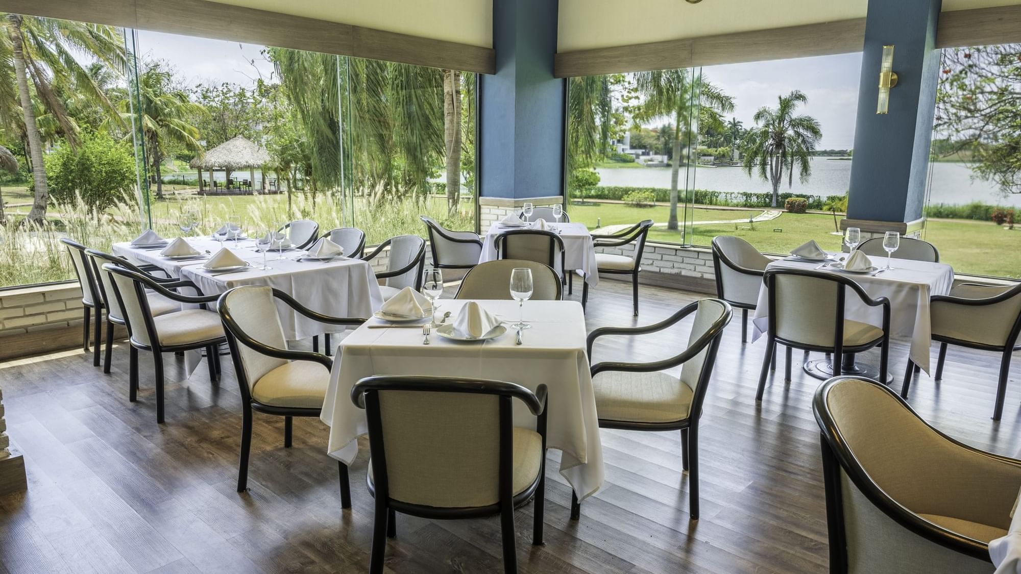 Elegant restaurant with white tablecloths, elegant glassware, and a scenic view at Fiesta Inn Tampico