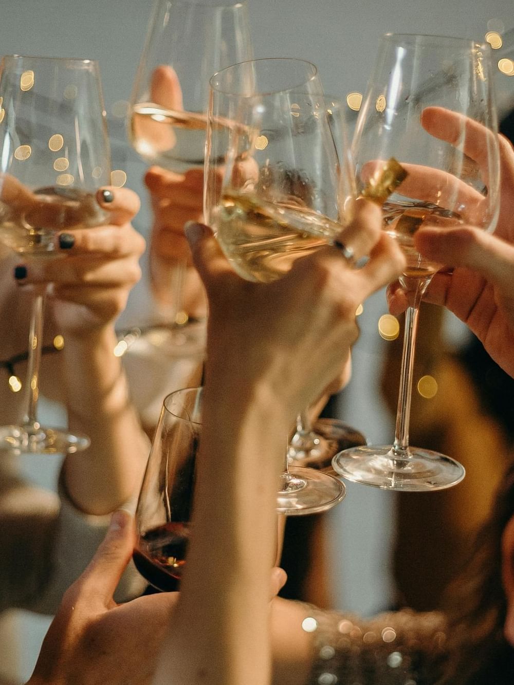 Un groupe de mains tenant des verres remplis de boissons lors de la célébration du Nouvel An au Warwick Hotels & Resorts.