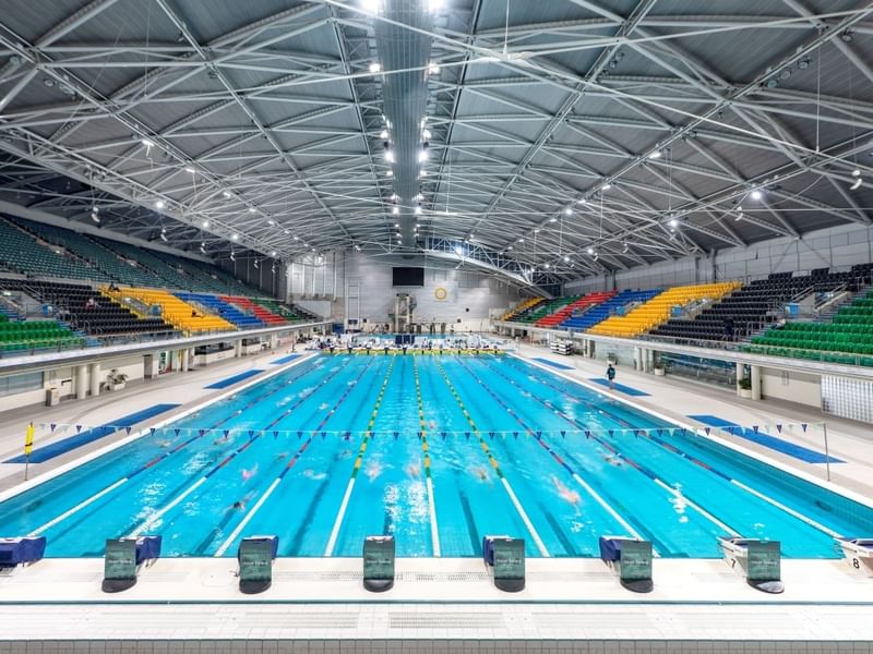 Interior view of the Sydney Aquatic Centre with a spacious pavilion near Pullman Sydney Olympic Park