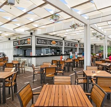 Dining area with wooden table set in Stella Beach Snack at Titanic Deluxe Lara