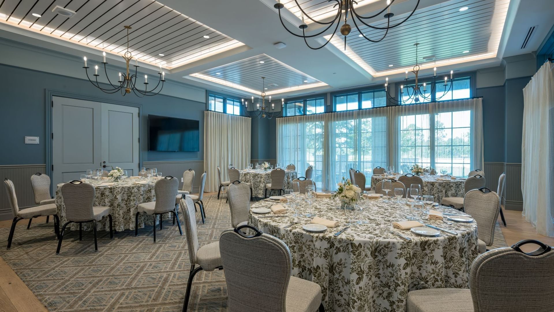 Elegant Club Room with floral-draped tables, chandeliers, and natural light at Camp Creek Inn in Inlet Beach.