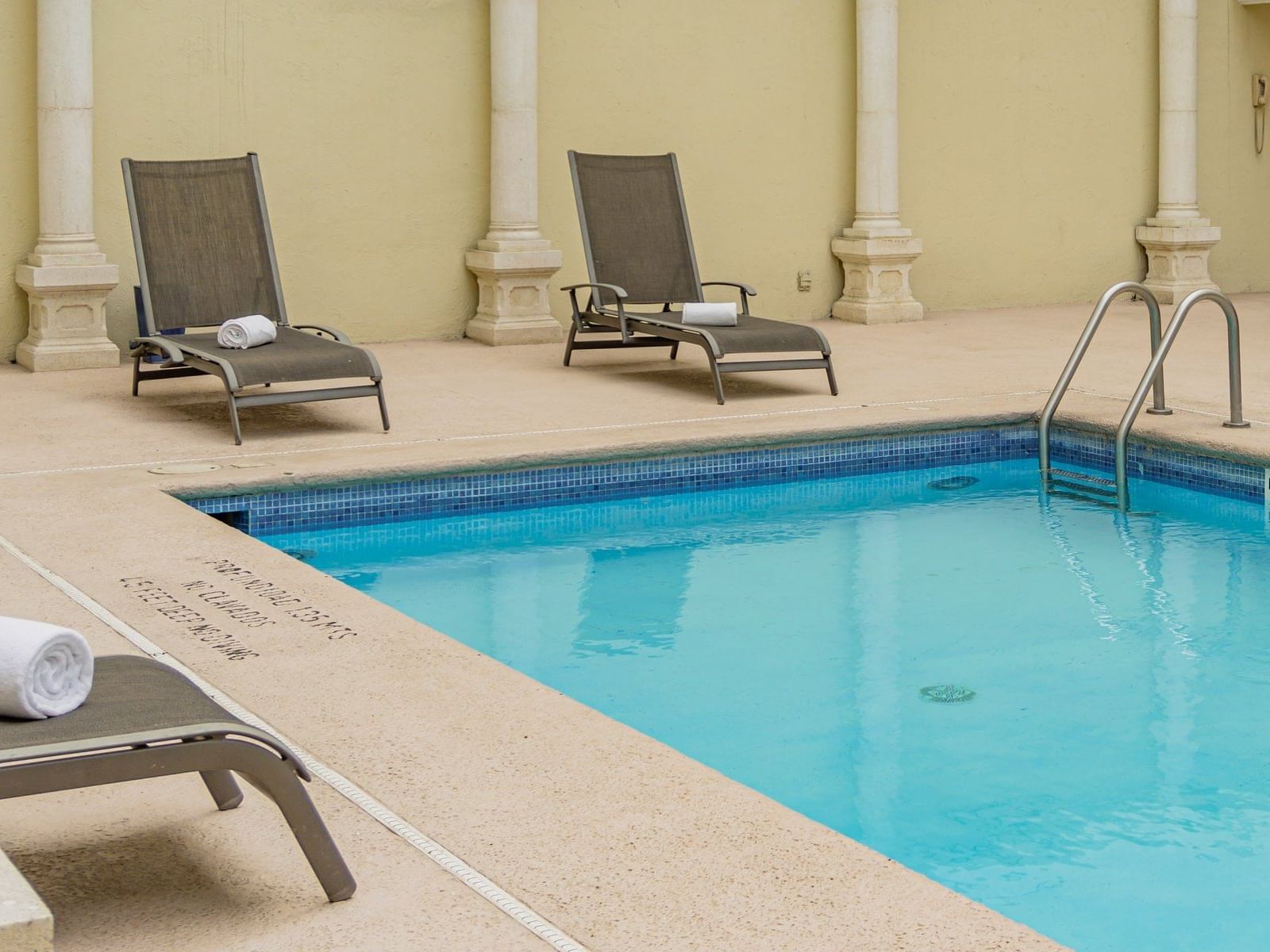 Sunbeds by the swimming pool in Alberca at Gamma Hotels